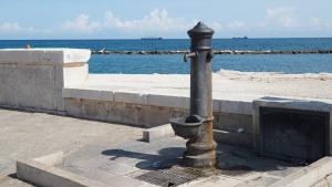 foto del lungo mare di bari con in primo piano una fontana di acquedotto pugliese 